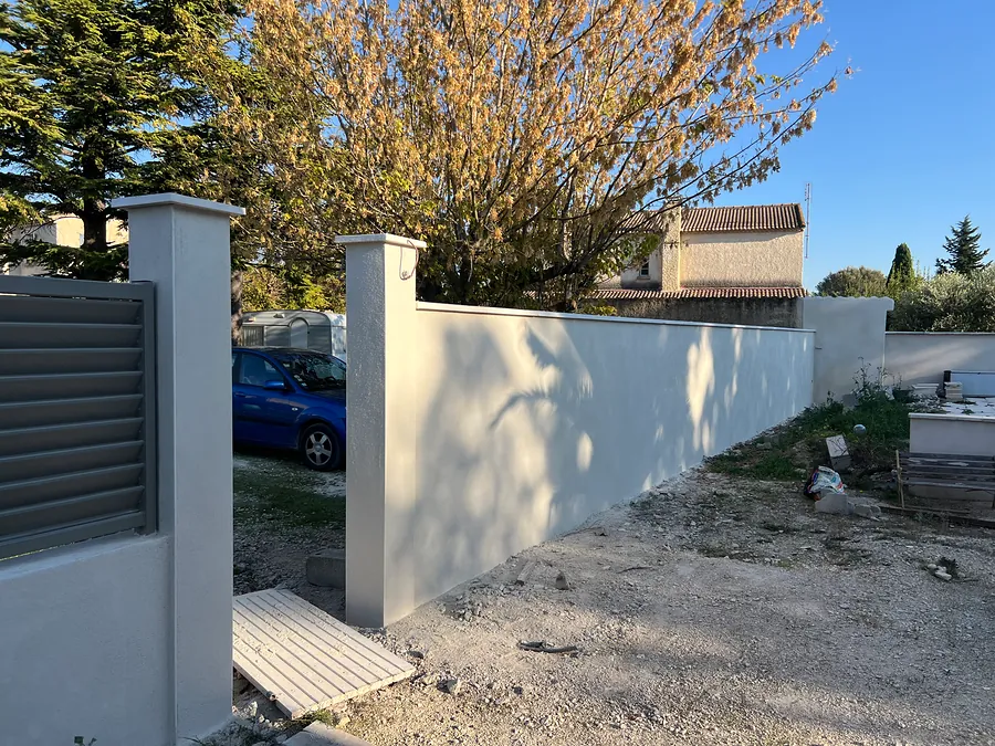 Piliers et mur de clôture plein enduits